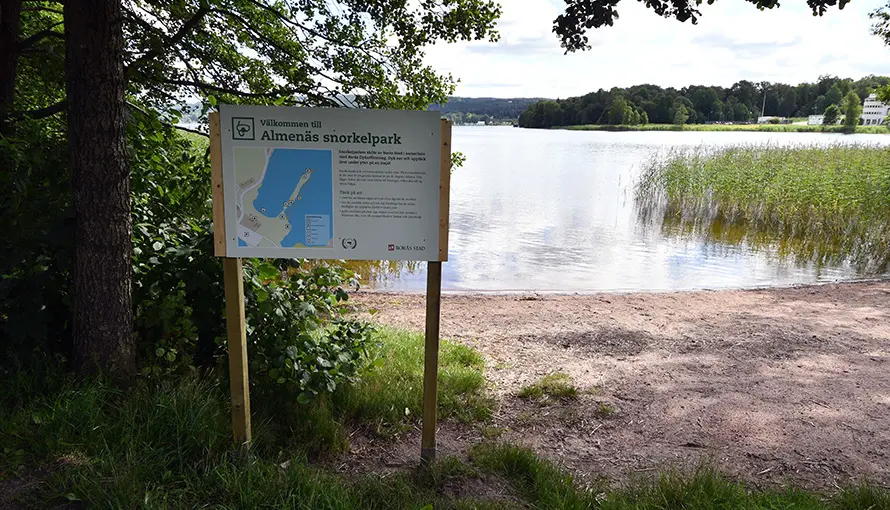 Snorkelpark på Almenäs med skylt som står vid strandkanten
