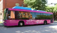 En stadsbuss som är dekorerade i rosa där det står Valbuss - här kan du rösta