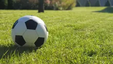 Fotboll som ligger på grön gräsmatta