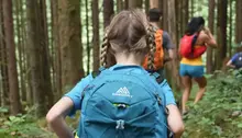 Barn bakifrån bär på blå ryggsäck