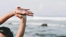 Person som sträcker sig framför ett hav