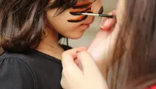 Barn blir målad i ansiktet med pensel