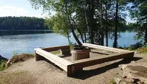 Grillplats med träbänk runt precis vid sjö